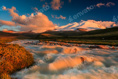 Preview: The picturesque mountain landscape with a creek at sunset sky background.