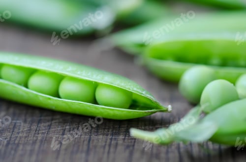 Preview: Green organic peas on wooden background, shalow focus