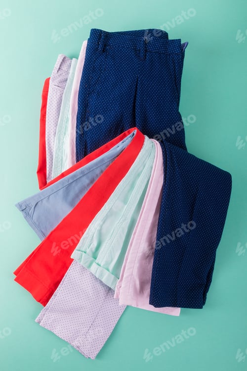 Preview: Stack of bright female trousers.