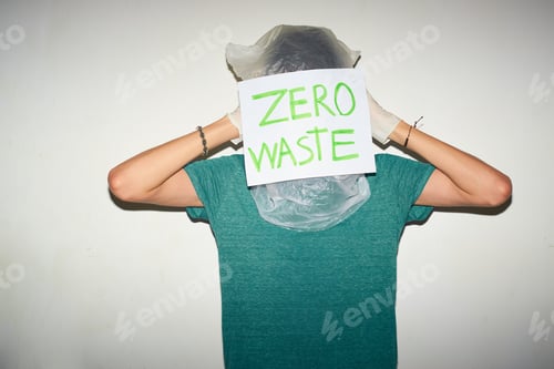 Preview: Young man with plastic bag on his head. Zero waste concept.