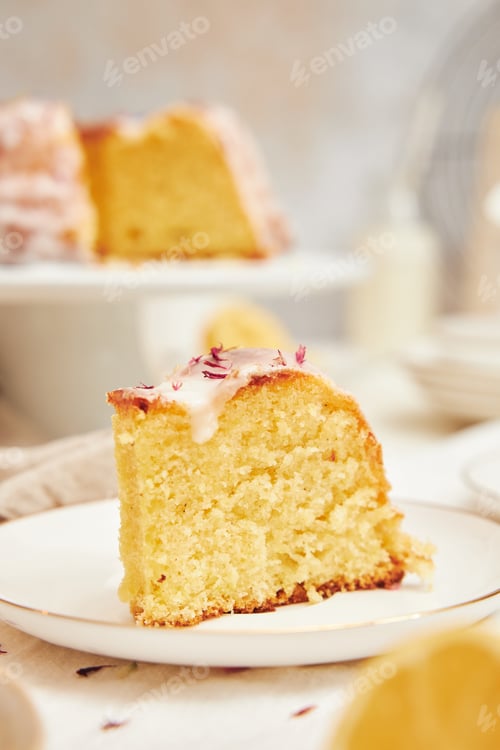 Preview: Vertical shot of a delicious citron cake with glaze and flower on top on a white table