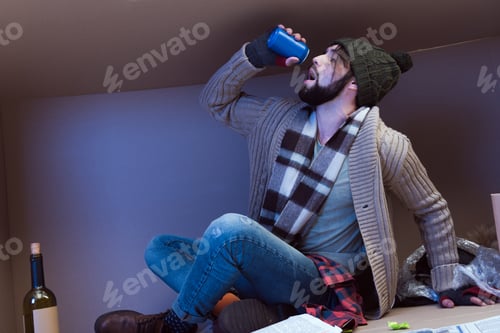 Preview: homeless man drinking alcohol while sitting in big cardboard box