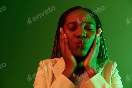 Preview: African american woman portrait business smile on green background in neon light, color mixed light