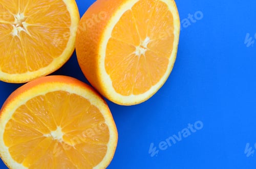 Preview: Top view of a several orange fruit slices on bright background in blue color