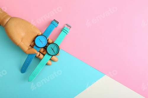 Preview: Wooden decorative hand and stylish wrist watches on color background, flat lay. Space for text