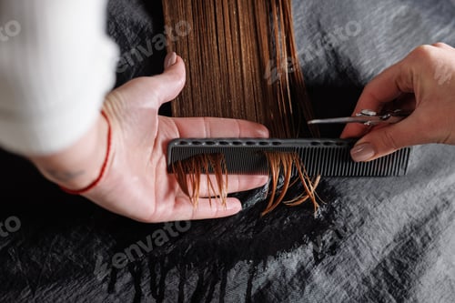 Preview: hairdresser makes a haircut to a woman in the salon