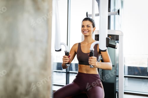 Preview: Beautiful fit young woman training in gym