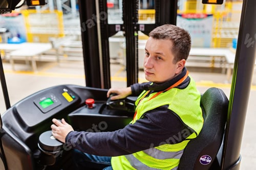 Preview: Young Caucasian forklift operator working on warehouse. Industrial man employee