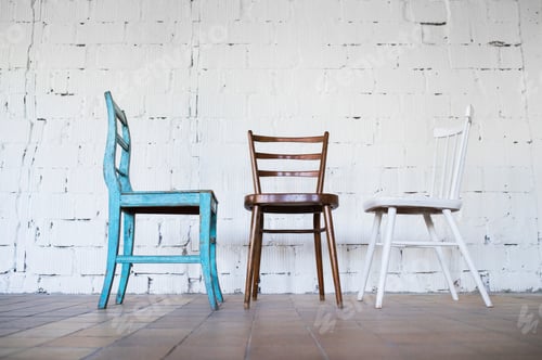Preview: Empty chairs against white brick wall