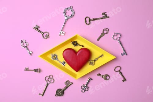 Preview: Flat lay composition with different keys and decorative heart on color background