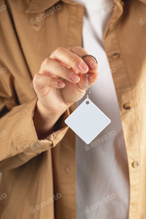 Preview: Keychain mockup to display design. Key chain mock up in woman hand. Blank rhombus white key chain