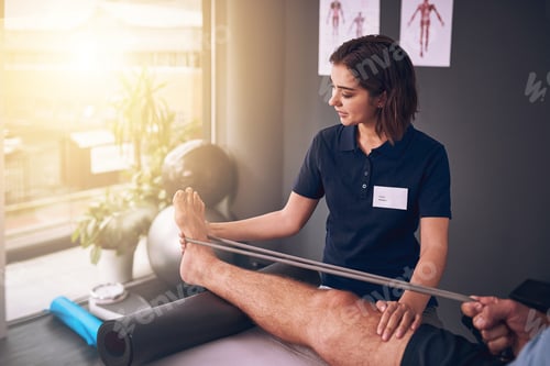 Preview: Cropped shot of an attractive young female physiotherapist treating a male patient