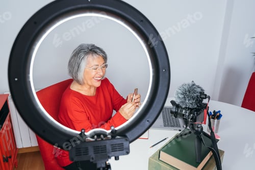 Preview: Beautiful old lady smiling and doing a make up tutorial for social media.