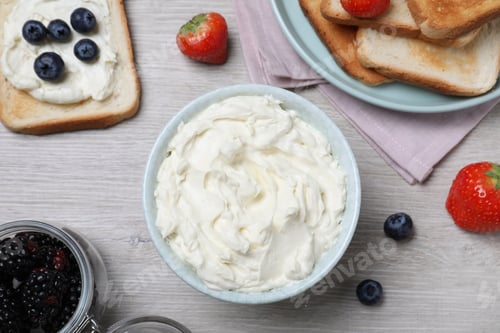Preview: Tasty cream cheese, toasted bread and fresh berries on white wooden table, flat lay