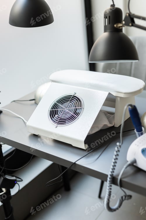 Preview: Modern table with nails color palette and lamp situating in salon. Workplace for manicure. Interior