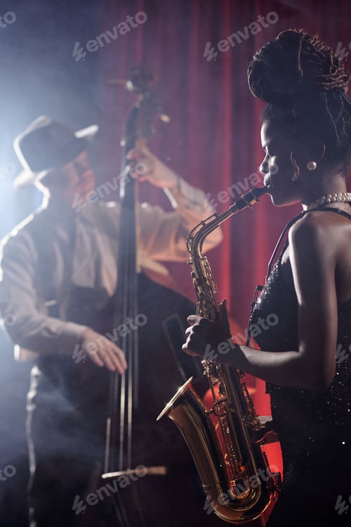 Preview: Young Black Woman Performing Saxophone Solo Beside Caucasian Man Playing Bass