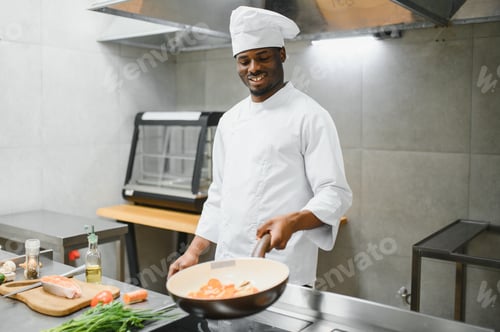 Preview: African American male chef standing at kitchen counter in restaurant kitchen, copy space