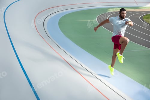 Preview: Young male athlete jogging on the running track