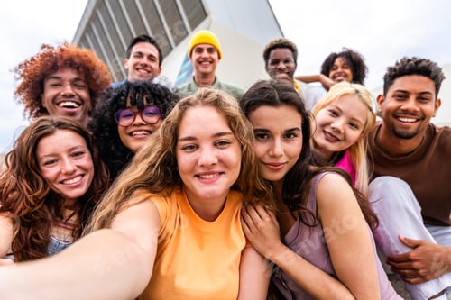 Preview: Happy playful multiethnic group of young friends bonding outdoors