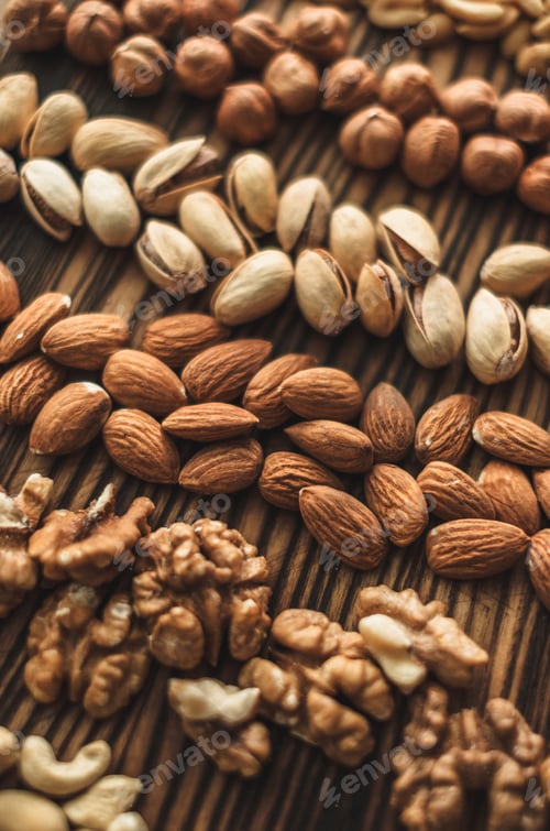 Preview: Different types of nuts, nut mix of almonds, hazelnuts, cashews, peanuts on a wooden board. Close up