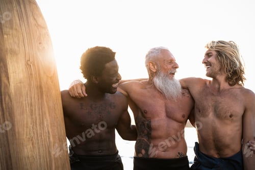 Preview: Happy fit surfers with different age and race having fun surfing together at sunset time