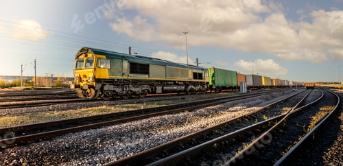 Preview: A UK freight train with locomotive and wagons transporting shipping container boxes