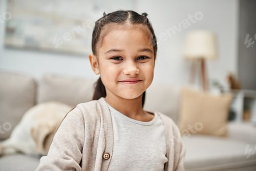 Preview: portrait of happy elementary age girl with brunette hair smiling at camera in modern apartment