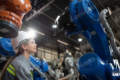 Preview: A female engineer installs a program on a robotics arm in a robot warehouse