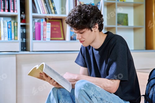 Preview: Portrait of college student guy reading bool inside classroom of educational building