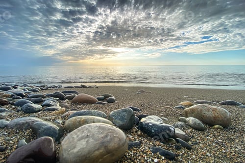 Preview: Beautiful seascape with pebbles and clouds in the sky. Concept of sunset or sunrise