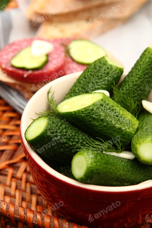 Preview: Homemade fresh salted cucumbers in the bowl on wicker tray
