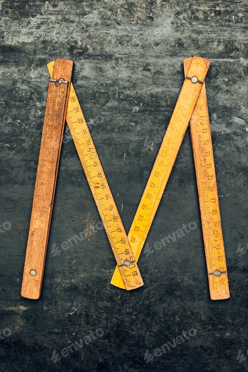 Preview: M like measuring. Wooden measure. Old ruler on metal surface. Measuring tool. Technical background