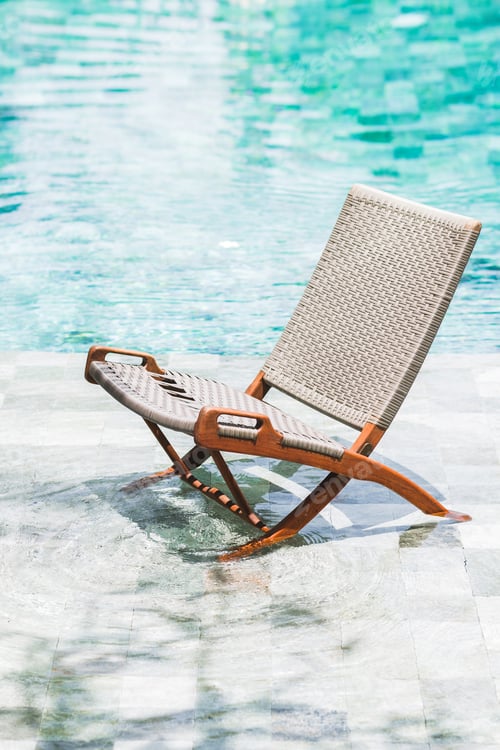 Preview: Folding rattan chair chaise longue by the pool. Clear transparent water