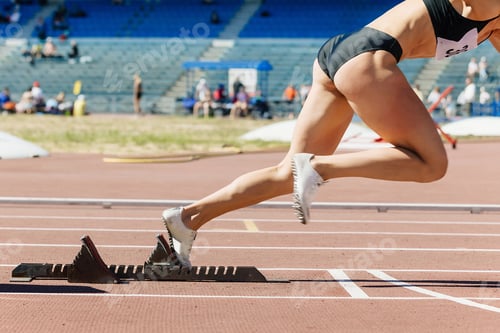 Preview: close-up female sprinter start from starting blocks run on stadium track