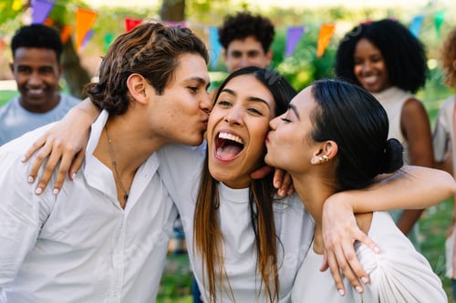 Preview: Friends kissing woman on cheek at a party