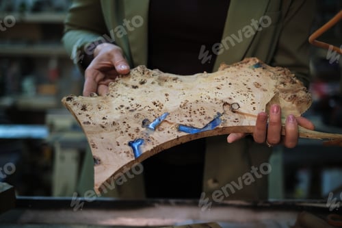 Preview: A woodworker s hands carefully assess a piece of burl, where the swirls and knots speak of the wood