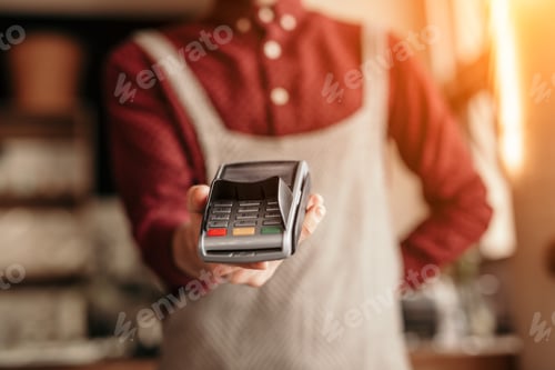 Preview: Crop waiter offering payment terminal