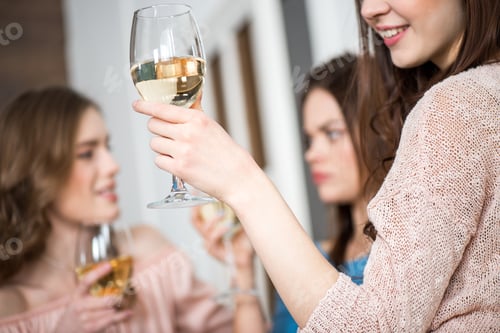 Preview: Midsection view of young woman holding glass of white wine