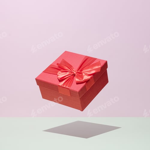Preview: Gift in a red box in levitation on a pastel background wedding celebration congratulations concept.
