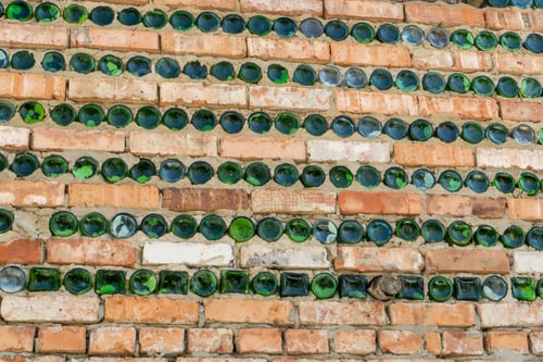 Visualização: A parede da casa é feita de tijolos e garrafas verdes de vidro.