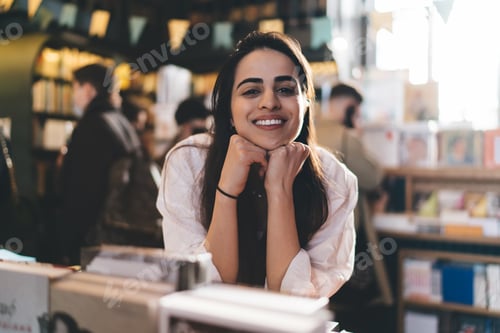 Preview: Smiling woman with books in library