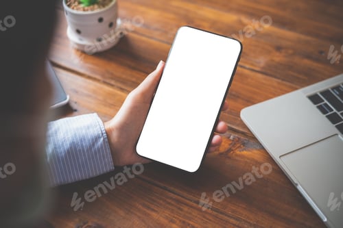 Preview: close-up mockup image of hand holding black mobile phone with blank white in desk work for home.