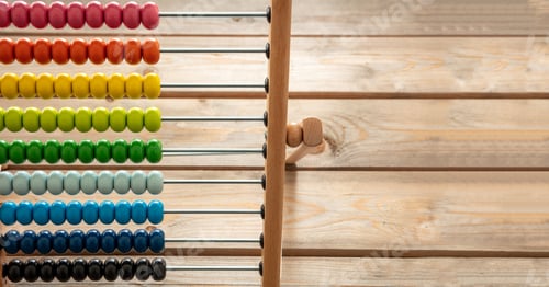 Preview: School abacus with colorful beads on wooden desk, close up view