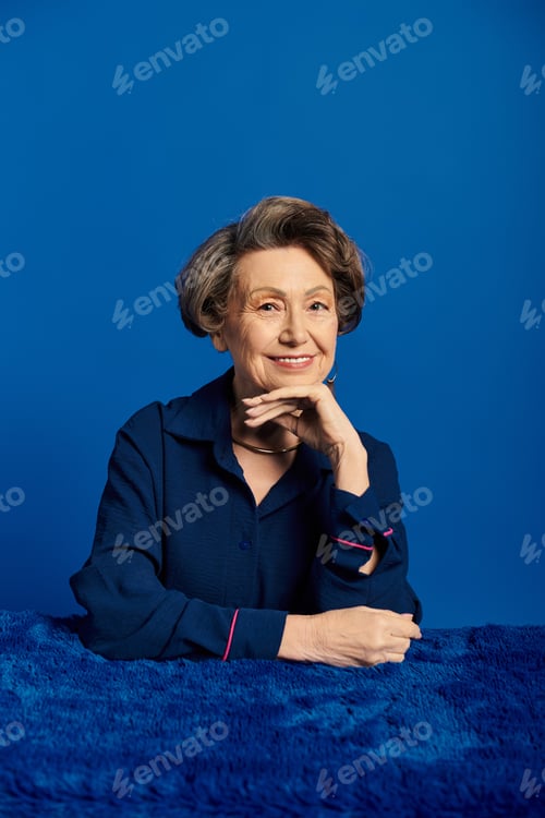 Preview: A beautiful woman in her 60s poses gracefully with a smile, showcasing her timeless elegance.