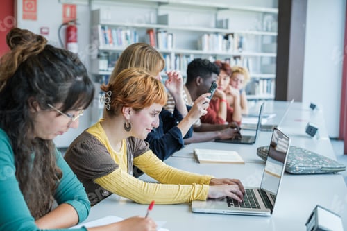 Preview: Group of college students studying together in the library