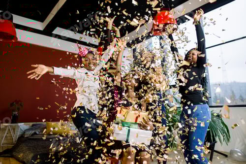 Preview: Happy African American friends girls under falling confetti at the birthday party