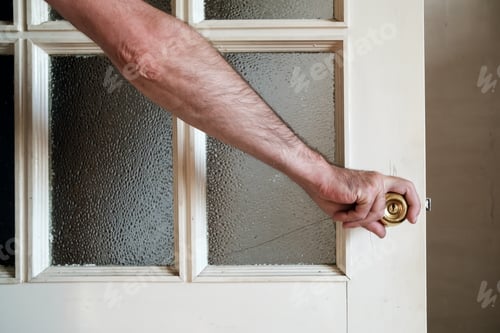 Preview: Male hand closes a white painted wooden door with frosted glass in a country house