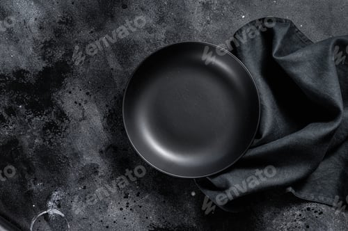 Preview: Black plate and a towel on textured black background. Top view. Copy space