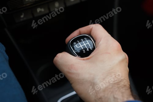 Preview: Man hand on a mechanical gearbox in the car. Man driving car. Car interior details. Car 6 speed