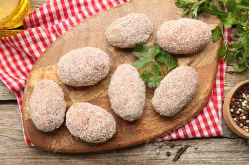 Preview: Uncooked meat patties, parsley and peppercorns on wooden table, flat lay